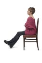 side view of a woman in tight jean pants sitting on chair cross legged and arms crossed