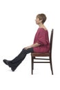 side view of a woman in tight jean pants sitting on chair relaxed and cross legged