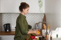 Side view woman washing fresh vegetables in kitchen Royalty Free Stock Photo