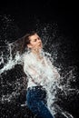 side view of woman in white shirt and jeans swilled with water