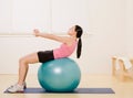 Side view of woman working out on exercise ball