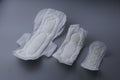 Side view of women sanitary pad in various size on grey background