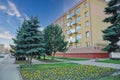 Side view of a yellow apartment building in the daytime with trees in front in Leszno, Poland