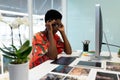 Stressed female graphic designer sitting at desk