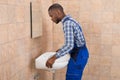 Male Plumber Fixing Sink In Bathroom Royalty Free Stock Photo