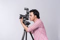 Side view of young asian photographer holding digital camera, while working in studio Royalty Free Stock Photo
