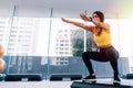 Side view of young attractive Asian fitness woman in sportswear doing deep squat at gym