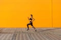 Side view of young attractive sporty woman wearing black sporwear practicing sport exercises in morning on street, start to run Royalty Free Stock Photo