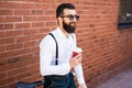 Side view of young bearded man drinking coffee while sitting on his bicycle outdoors Royalty Free Stock Photo