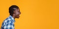 Side view of young black man shouting at free space on yellow background. Royalty Free Stock Photo