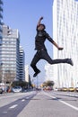 Side view young black man wearing casual clothes jumping in urban background. Lifestyle concept. Millennial african guy wearing Royalty Free Stock Photo