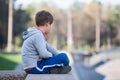Side view of young boy sitting lotus position on granite curb Royalty Free Stock Photo