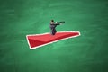 Side view of young businessman with telescope flying on abstract red paper plane on chalkboard wall background. Leadership, Royalty Free Stock Photo