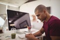 Side view of young businessman using mobile phone while sitting at desk Royalty Free Stock Photo