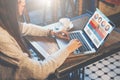 Side view. Young businesswoman sitting in cafe at table and using laptop.On desk is cup of coffee. Royalty Free Stock Photo