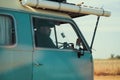 Side view of a young caucasian driver of a blue vintage van
