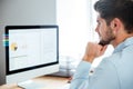 Side view of young confident businessman with laptop in office Royalty Free Stock Photo