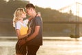 side view of young couple hugging and going to kiss on river beach Royalty Free Stock Photo