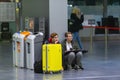 Side view of young couple sitting and waiting registration by the check-in counters in pulkovo airport