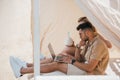 side view of young couple using laptop and drinking cocktail in bungalow Royalty Free Stock Photo