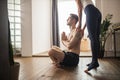 Side view on cropped woman helping man in practicing yoga Royalty Free Stock Photo