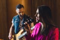 side view of a young dark-haired girl singing into a microphone and a guitarist playing in the background, band concept Royalty Free Stock Photo