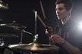 Side View Of Young Drummer Playing Drum Kit In Studio