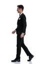 Side view of young elegant man smiling and walking Royalty Free Stock Photo