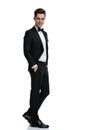 Side view of young elegant man in tuxedo walking Royalty Free Stock Photo