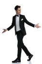 Side view of young elegant man walking and opening arms Royalty Free Stock Photo