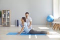 Woman doing exercise to restore back flexibility during physiotherapy after sports injury