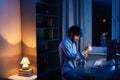 Side view of young freelancer working on computer and typing text on wireless keyboard at late night Royalty Free Stock Photo