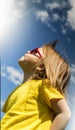 Side view of a young girl looking ahead in the park, against a blue sky background. Vertical. Royalty Free Stock Photo