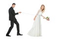 side view of young groom with chain and leashed shocked bride