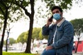 Side view of a young handsome man with a medical face mask talking on the phone Royalty Free Stock Photo