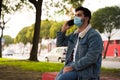 Side view of a young handsome man with a medical face mask talking on the phone Royalty Free Stock Photo