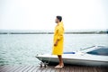 Side view of a young handsome sailor in yellow cloak