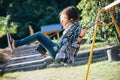 Side view of young happy girl on swing