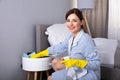 Housemaid Cleaning Furniture With Duster