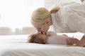 Side view young loving beautiful mother kissing her cute baby Royalty Free Stock Photo