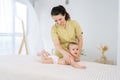 Side view of young loving mother giving back massage toddler son lying on bed, feeling love, express caress. Happy mom Royalty Free Stock Photo