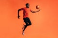 Side view of young male jumping and throwing up a basket ball in studio Royalty Free Stock Photo