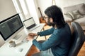 Side view of young male web developer wearing eyeglasses writing code on desktop computer while working from home Royalty Free Stock Photo