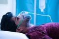 Side view on young man breathing on ventilator oxygen mask at hospital due coronavirus covid-19 dyspnea or breathlessness -