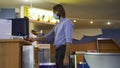 Side view of a young man buying the movie tickets at the movie theater hall. Media. Male in medical mask paying for