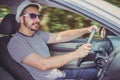 Side view of young man driving a car