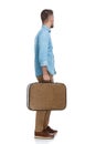Side view of young man holding luggage and leaving town Royalty Free Stock Photo