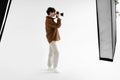 Side view of young man photographer taking photo using professional dslr camera and lighting equipment, full length Royalty Free Stock Photo