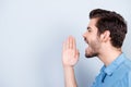 Side view of young man shouting isolated on light blue backgroun Royalty Free Stock Photo