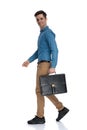 Side view of young man smiling and holding suitcase Royalty Free Stock Photo